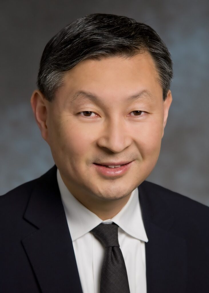 An Asian man wearing a suit and tie