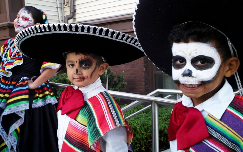 Two boys celebrating Dia de lo Muertos looking at the camera.