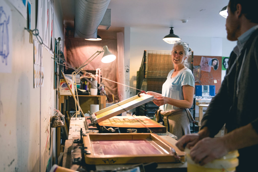 A woman in a screen-printing art studio.