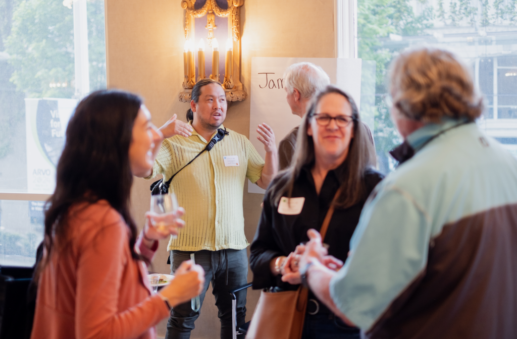 Four professionals from different arts nonprofits chat in a conference room.