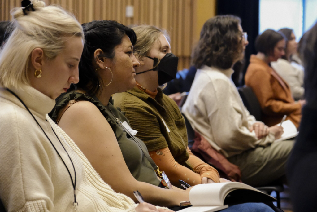 A row of professional women are sitting.