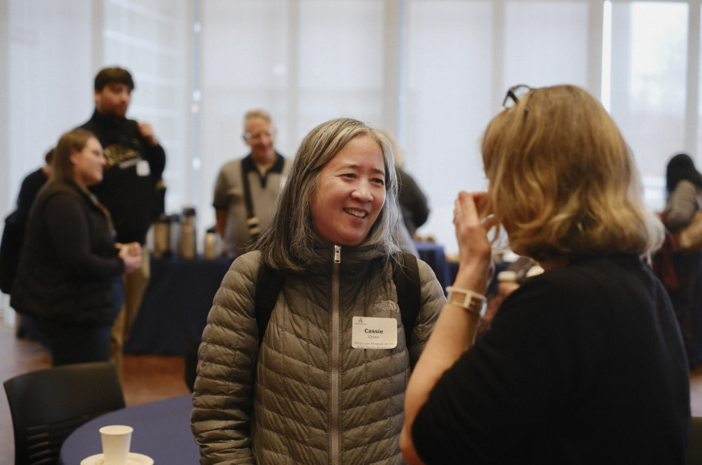 Two women converse at a conference.