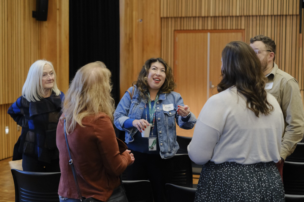 A group of professionals chat in a conference room.
