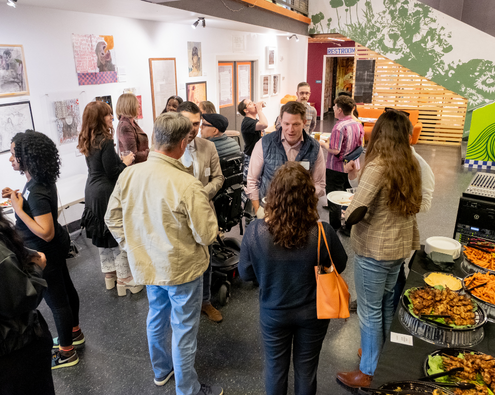 At an ArtsFund Networking event, young professionals mingle and enjoy refreshments.